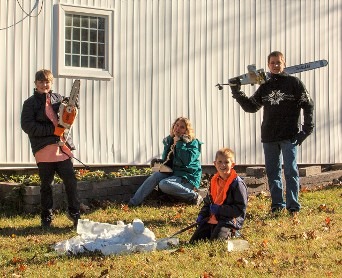 Ice carver operating a chainsaw tool on an outdoor ice sculpture project