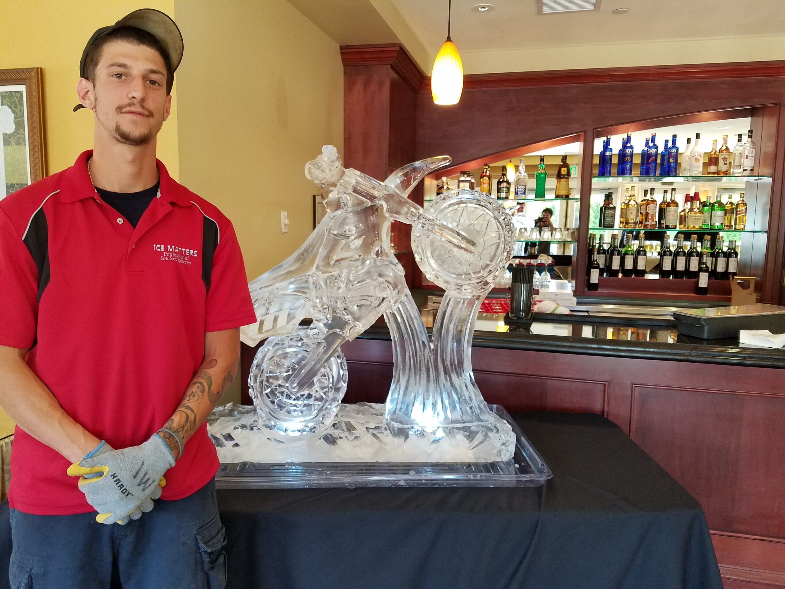 Chef or event coordinator standing next to an elaborate food station ice carving