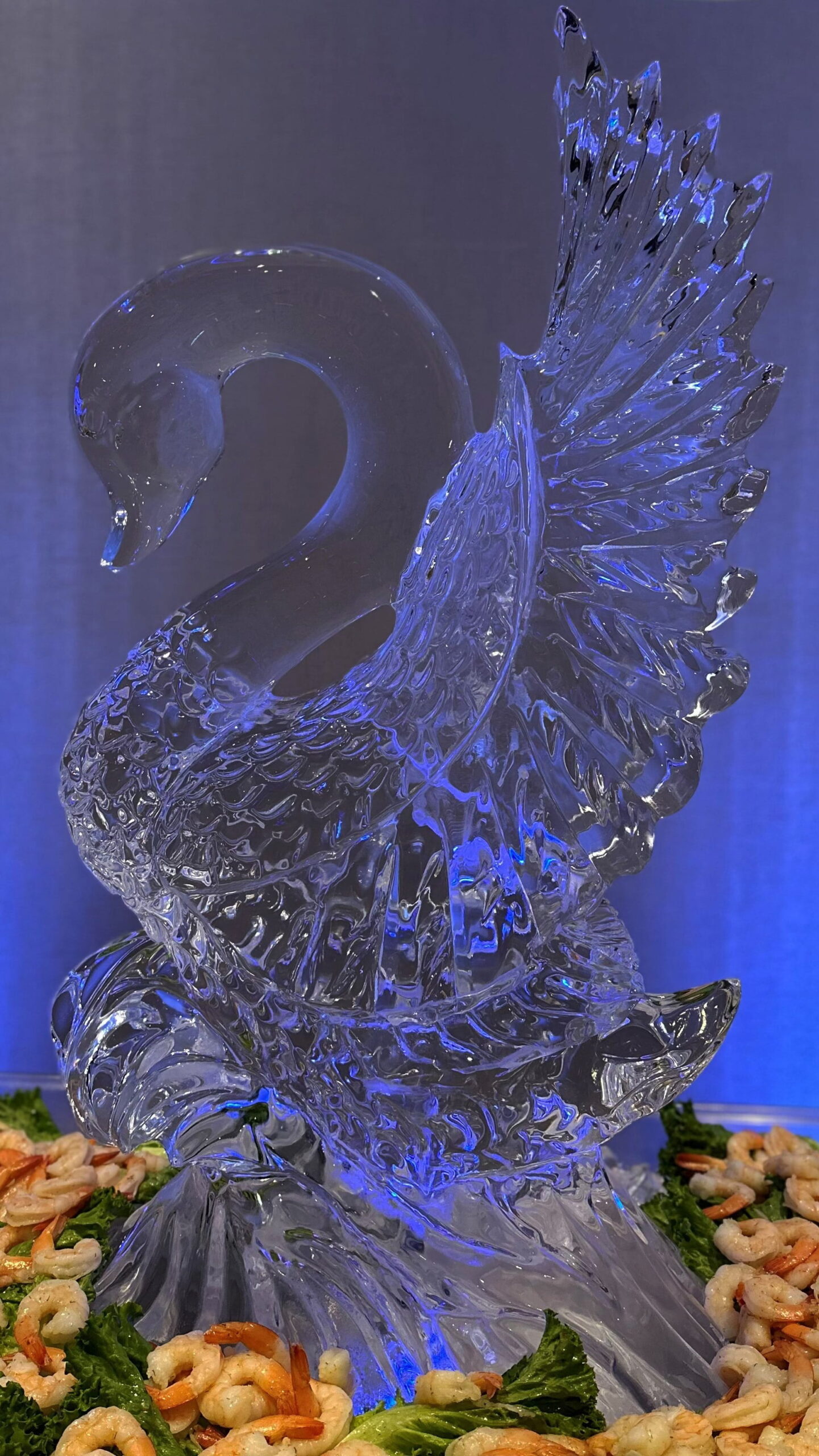 Stunning wedding swan ice sculpture illuminated with striking blue lighting