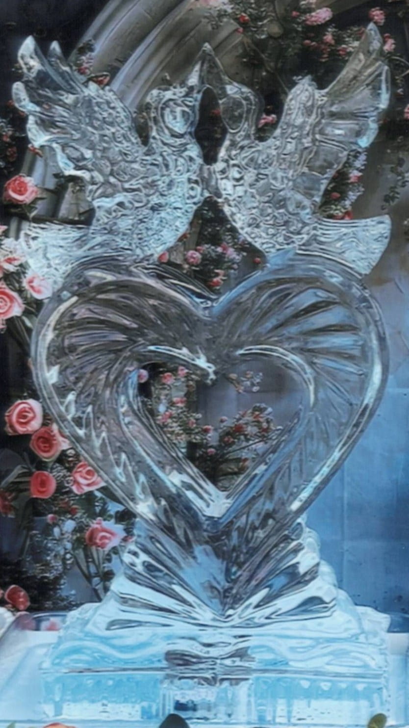 Heart shaped clear ice carving with detailed textured wing patterns