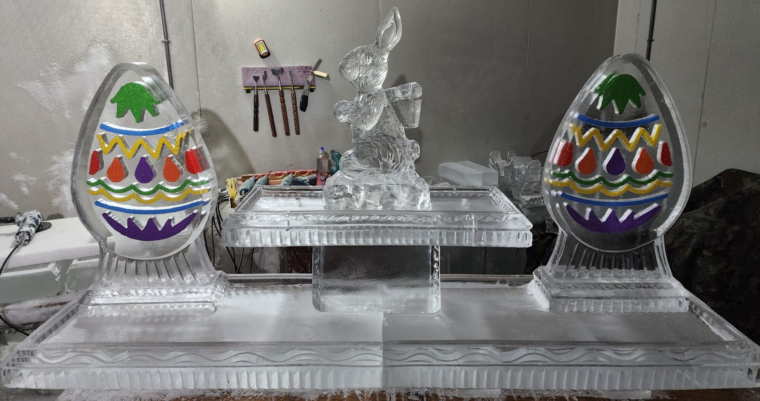 Ice matters - 80 inch base tray with colored egg on each side of raised tray holding bunny with backpack - colors vary