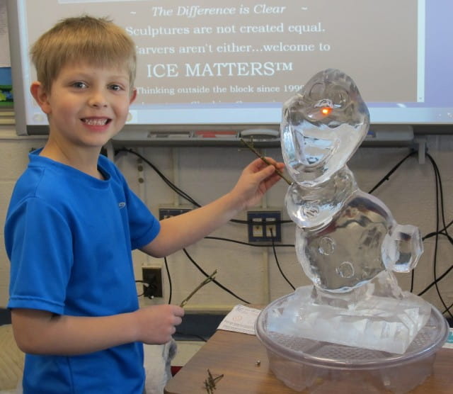 Child posing with custom ice sculpture