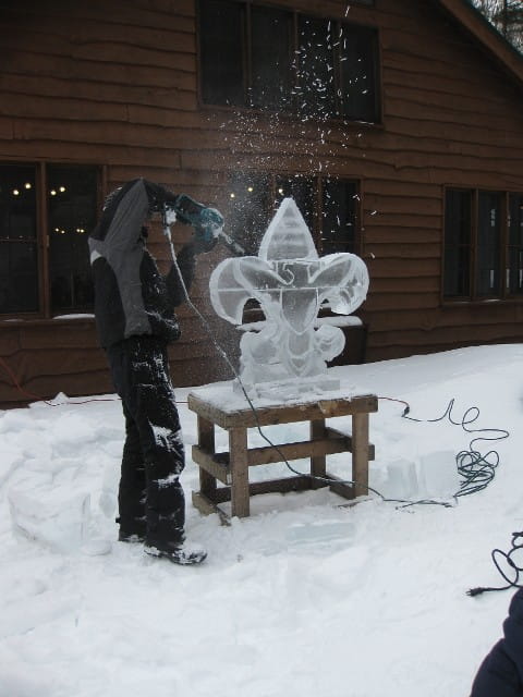 Elegant fleur-de-lis custom ice sculpture standing outdoors in the snow