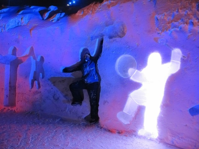 Performer executing a dynamic light prop routine inside a glowing blue ice room