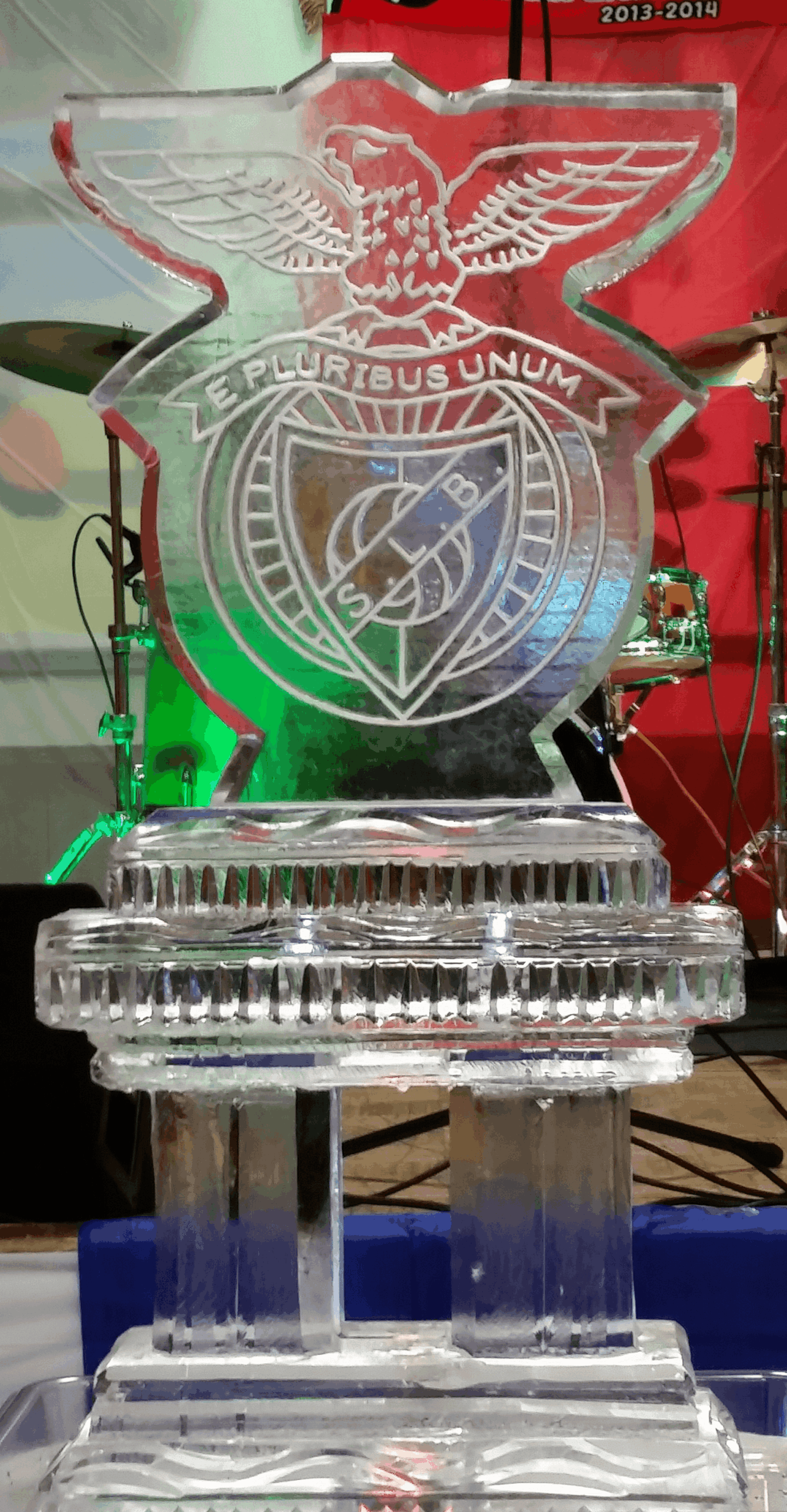 Custom corporate shield ice sculpture glowing with green LED lighting