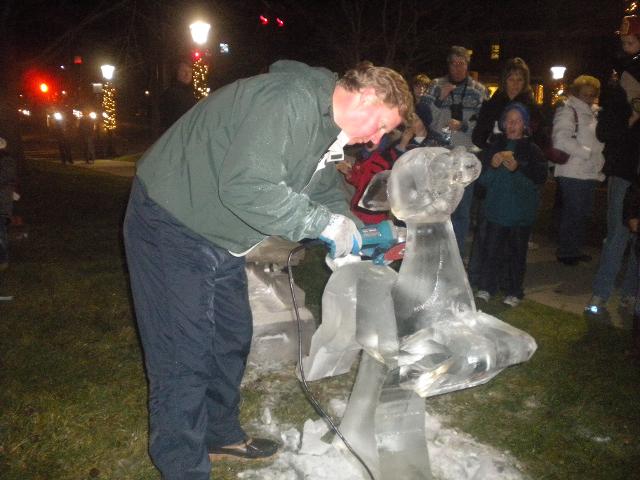 Sculptor focusing intensely while working on a detailed ice project outdoors