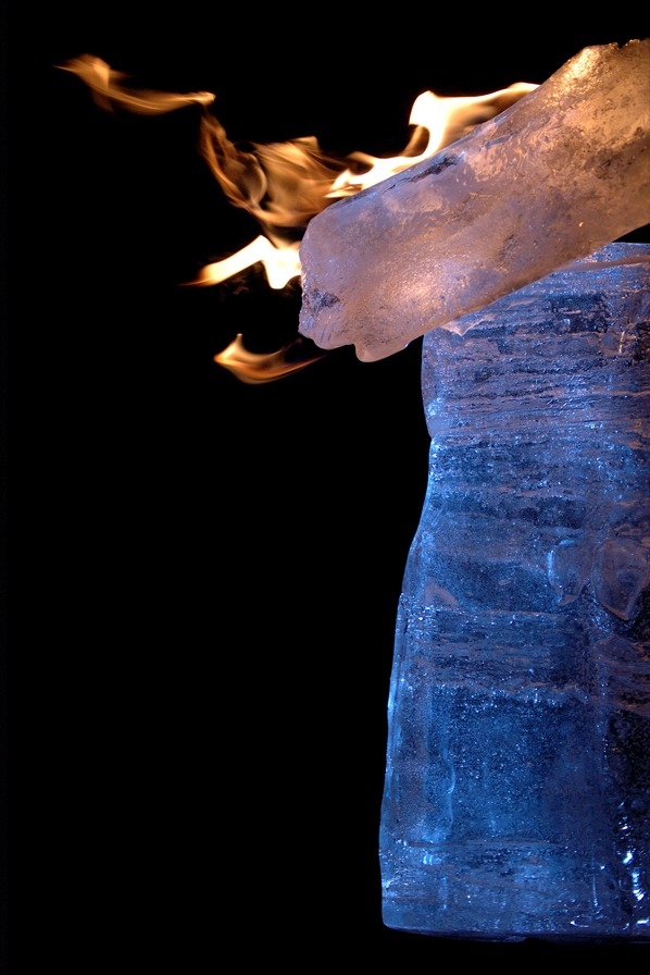 Outdoor ice sculpture installation under construction at night during a winter festival