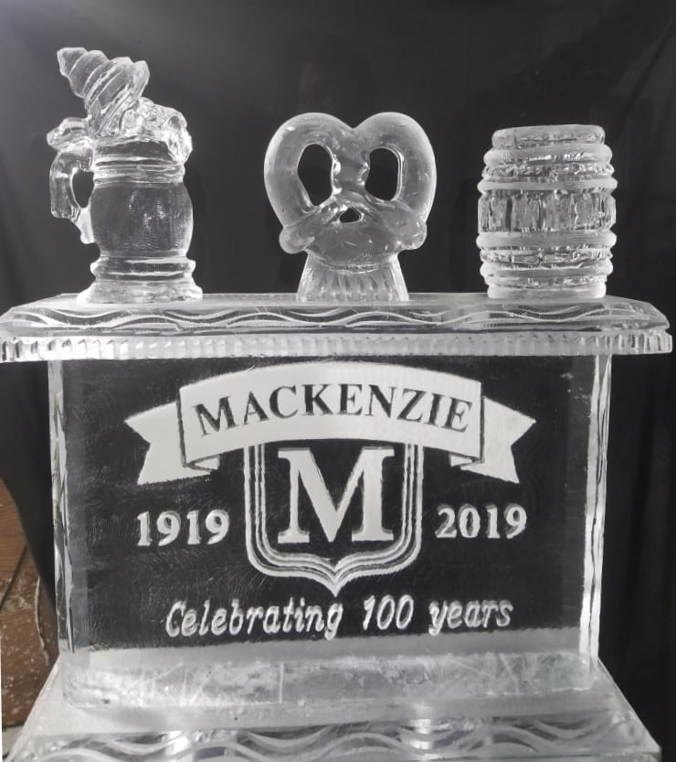 Mackenzie centennial anniversary ice carving featuring beer mugs and a monogram