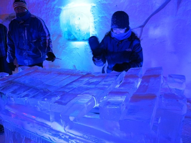 Production sound technician operating mixing gear inside an illuminated snow cave