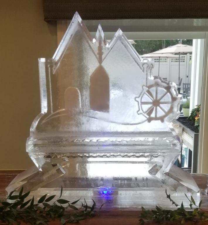Custom nautical themed ice sculpture with ship steering wheel and lighthouse