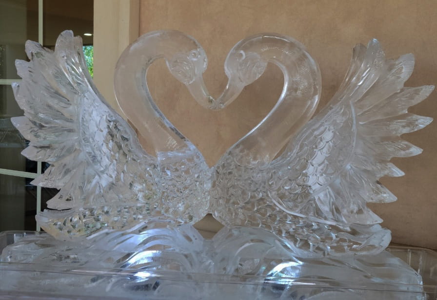 Close up of a clear ice sculpture showing two swans forming a heart