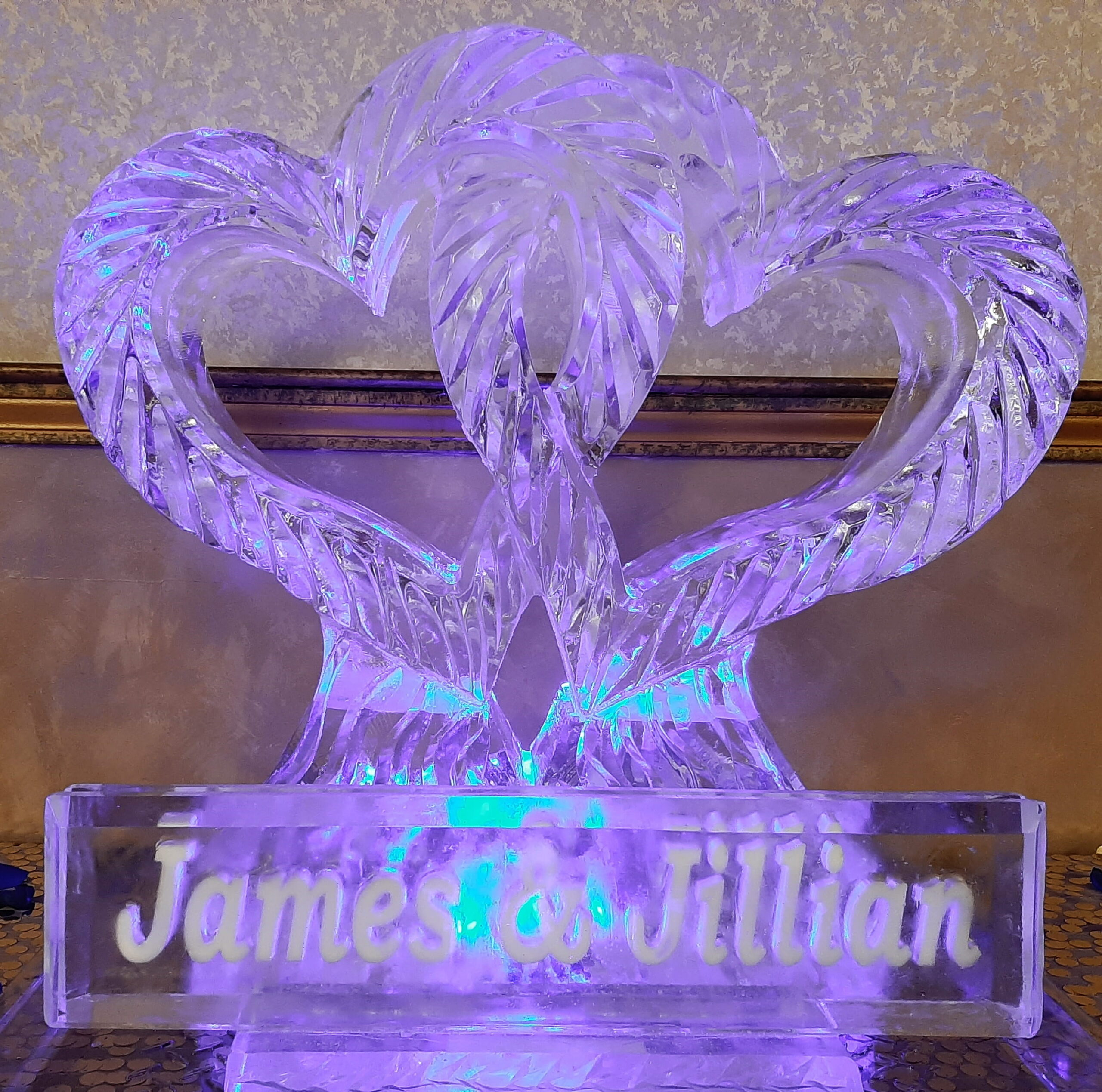 Double swan ice sculpture vibrant with purple and blue LED lighting