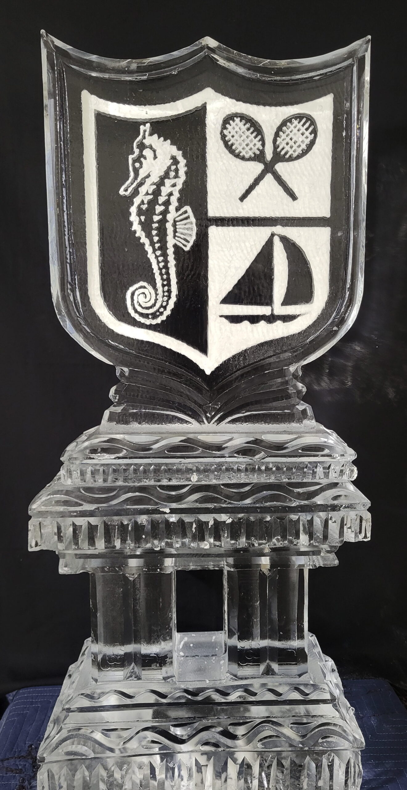 Detailed custom corporate shield ice carving featuring sailboat imagery