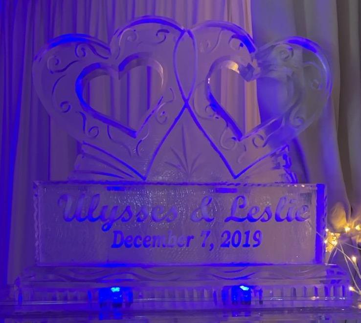 Interlocking wedding hearts ice carving glowing with purple LED light