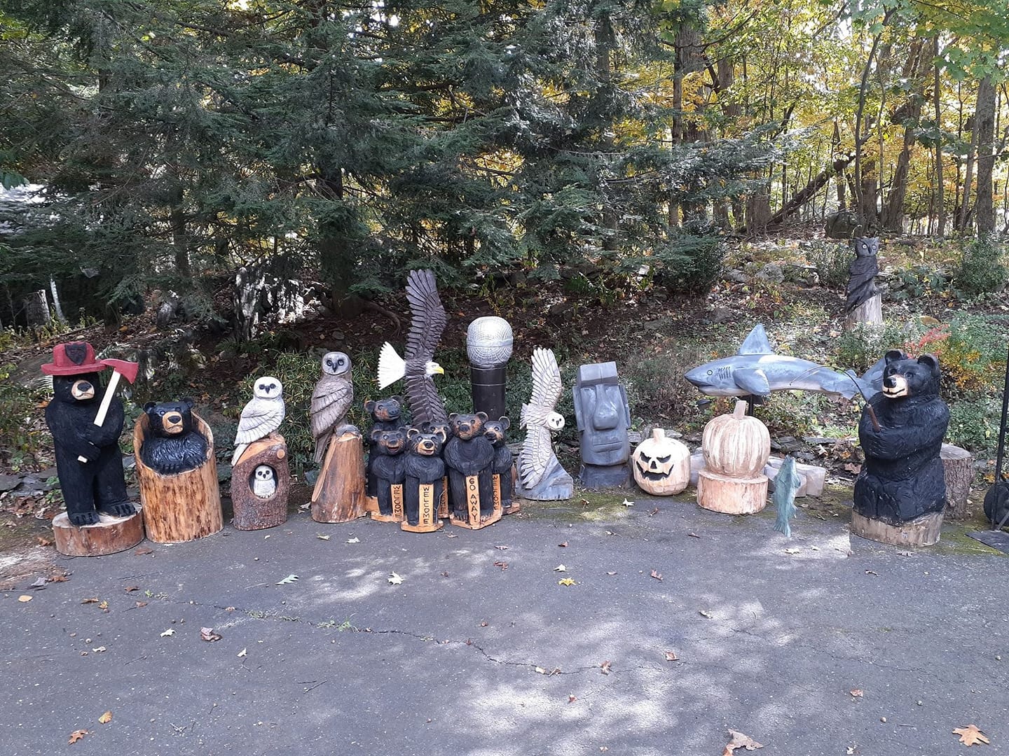 Collection of stone or metal animal sculptures placed in a garden landscape