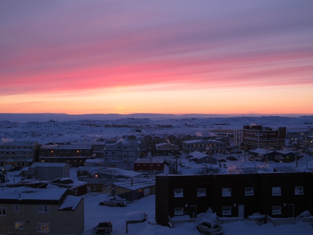 Vibrant sunset orange and purple gradient horizon sky over a snowy winter field