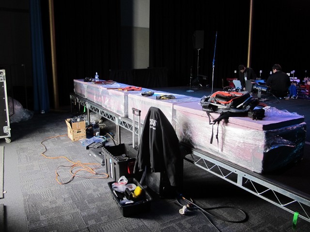 Event production backstage setup with gear cases, tools, and technical equipment