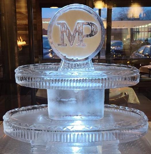 Circular monogram ice sculpture with illuminated base