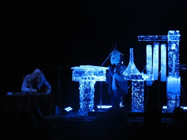 Sleek vertical clear ice pillars glowing with rich blue internal lighting