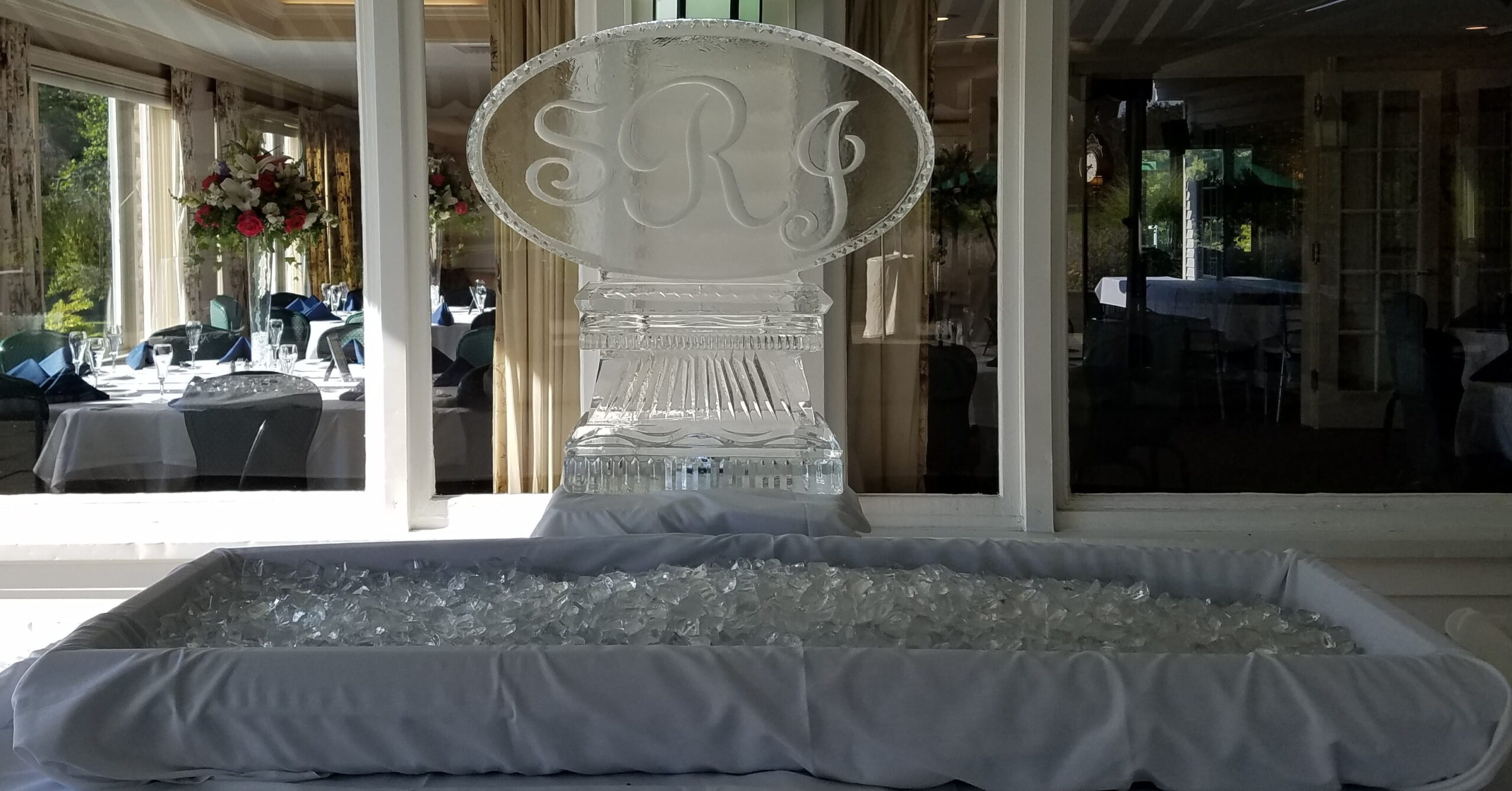 Custom engraved oval ice sculpture on display at an event venue