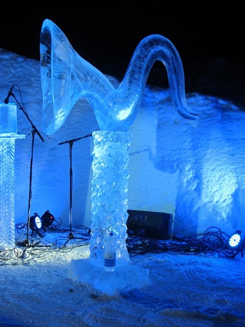 Large structural ice archway on display at an outdoor winter event grounds