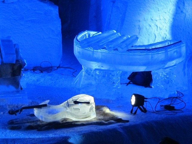 Sleek curved horizontal ice sculpture lit with bright blue LED spotlights