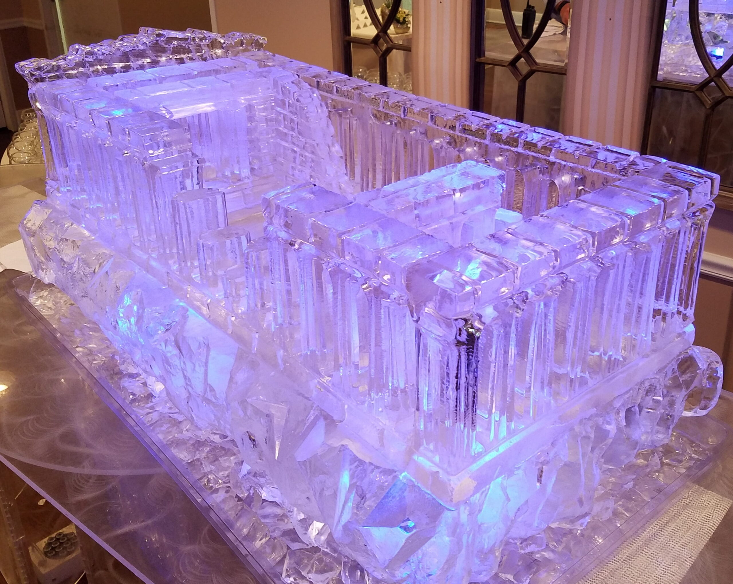 Purple illuminated ice bar with drink luge