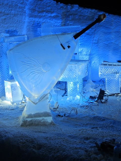 Unique sail or wedge shaped ice sculpture resting on an outdoor snow bed