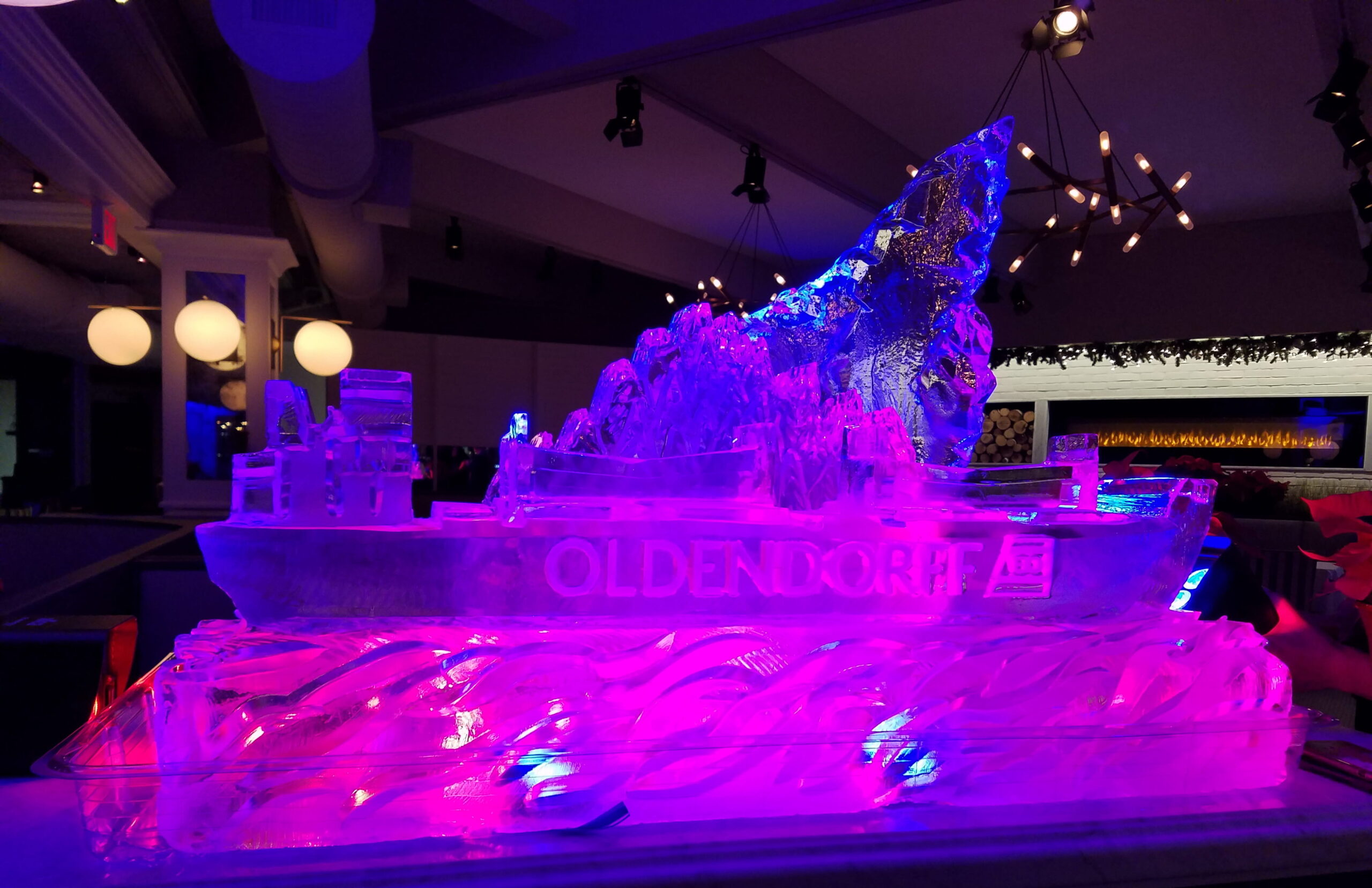 Vibrant pink and purple LED lit multi-layered wave ice sculpture installation