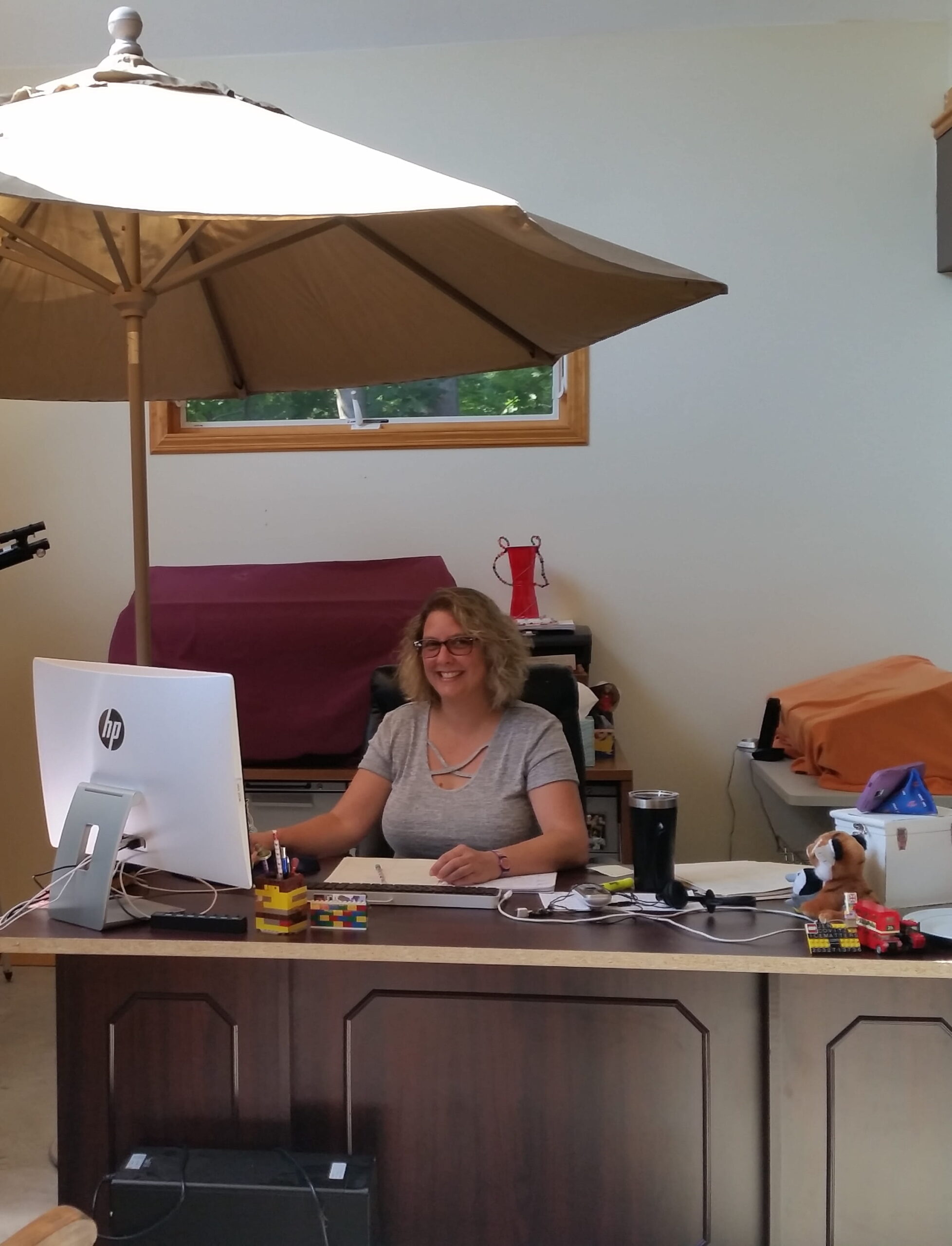 Woman smiling while working at a computer desk inside a bright home office