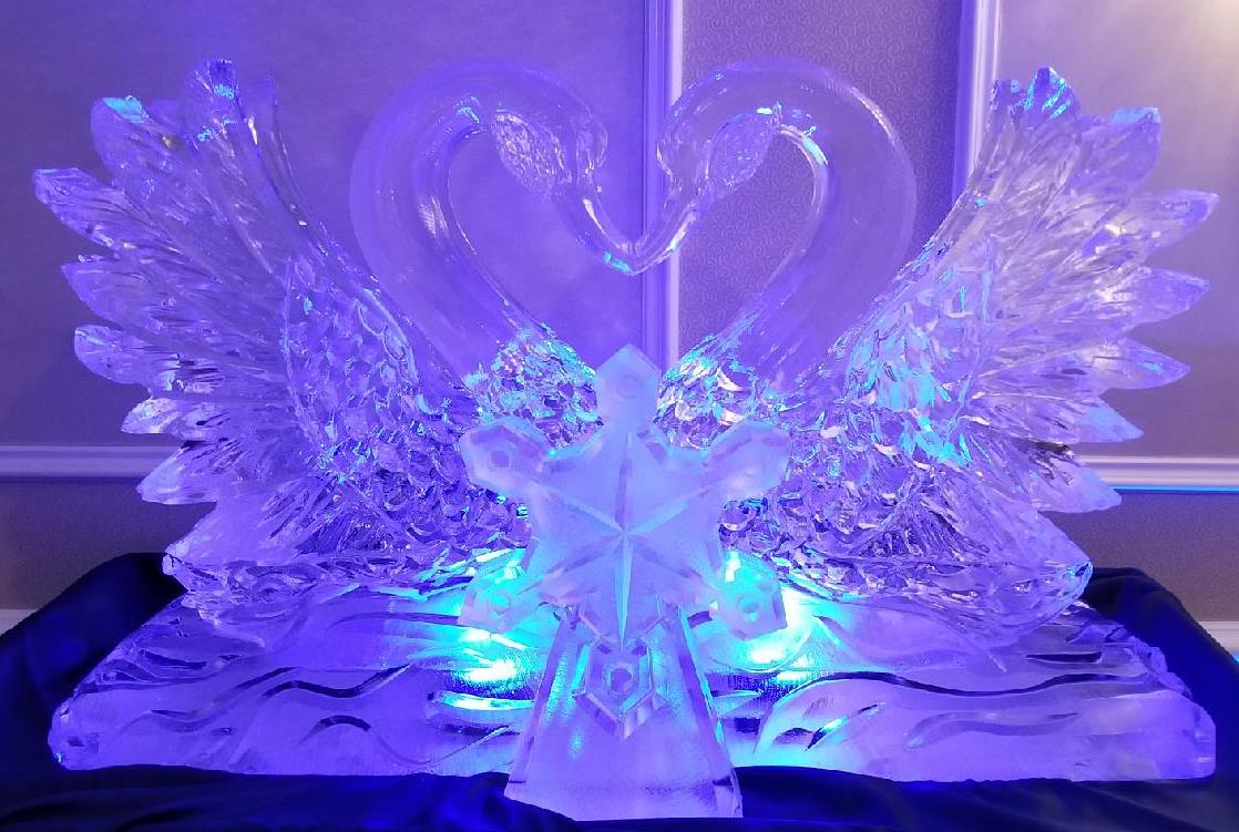 Vibrant purple LED lit double swan ice carving for a reception