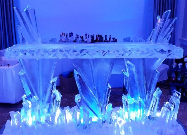 Elaborate multi-piece ice bar setup glowing under intense blue LED lighting
