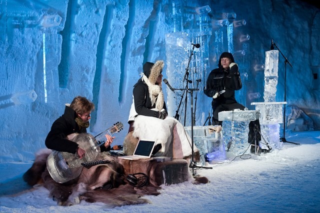 Live band performing music on a stage built entirely from clear ice blocks