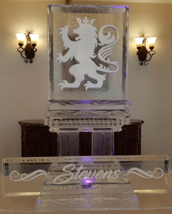 Custom monogram display ice sculpture on illuminated pedestal