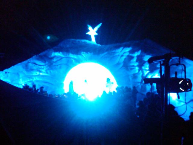 Stunning circular ice sculpture tunnel or arch glowing with brilliant blue light